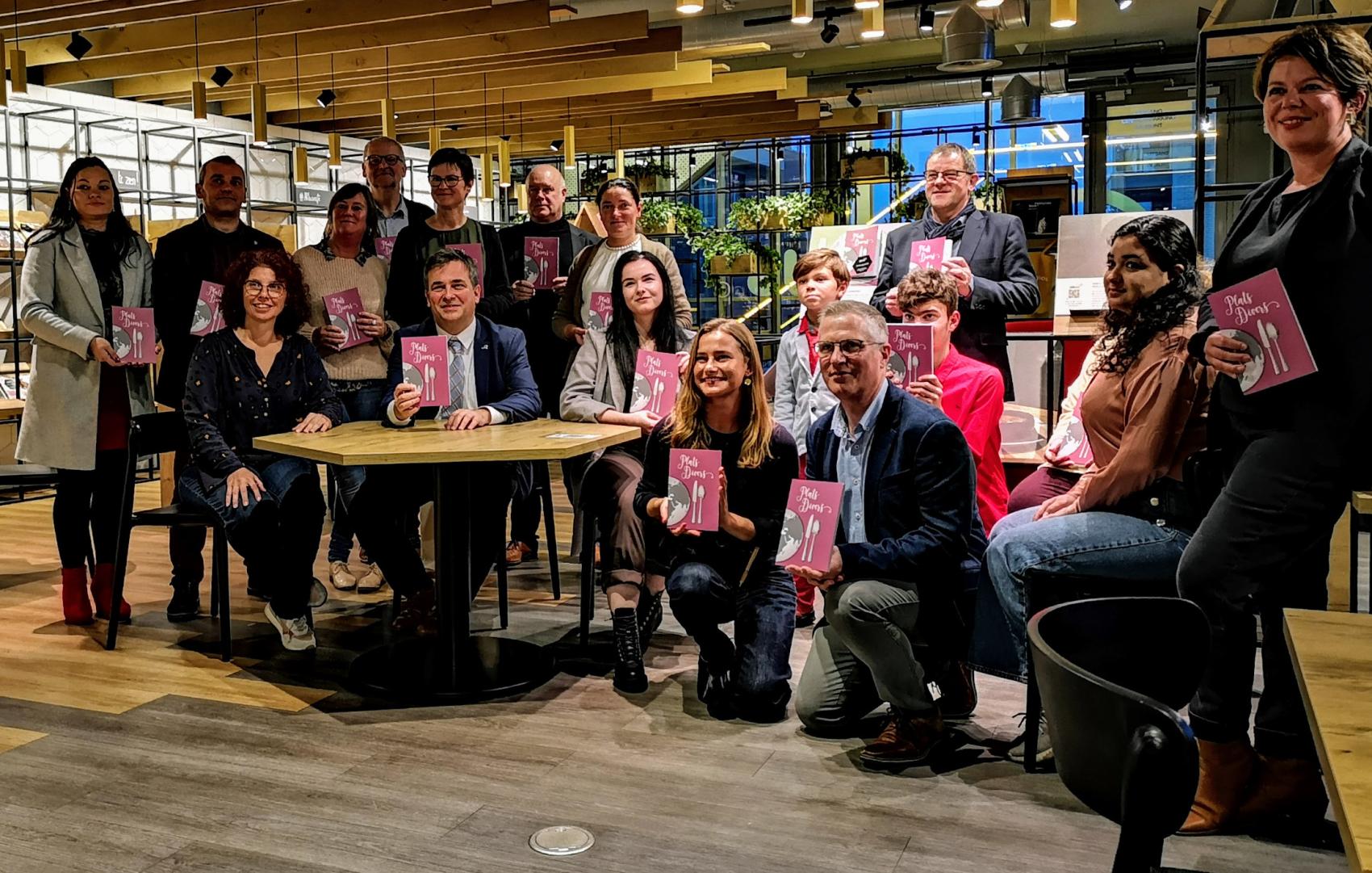 Medewerkers met boekje in hun hand